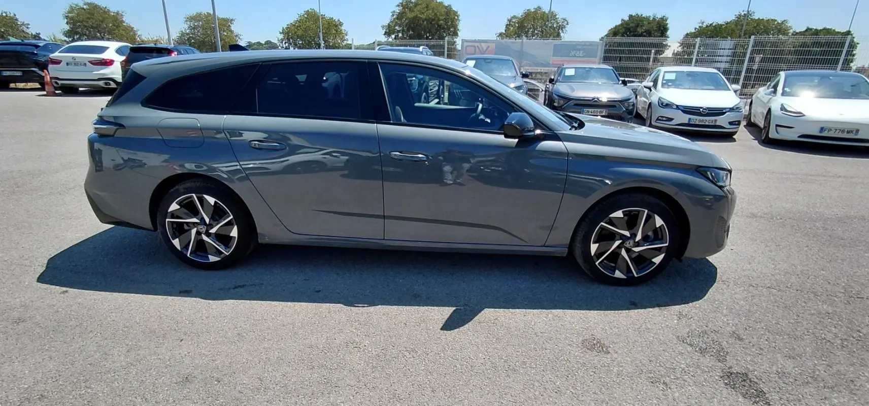Peugeot 308 SW Hybrid gris vue de profil côté gauche, avec jantes alliage 17 pouces et vitres teintées.