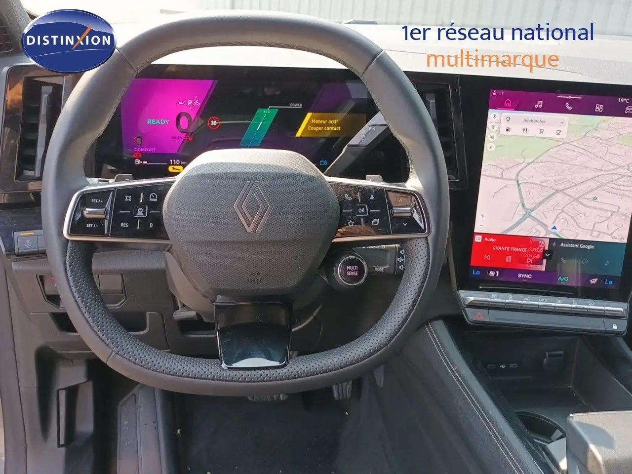 Vue intérieure centrée sur le volant Renault d’un Austral 2025, avec tableau de bord numérique et écran tactile affichant une carte.
