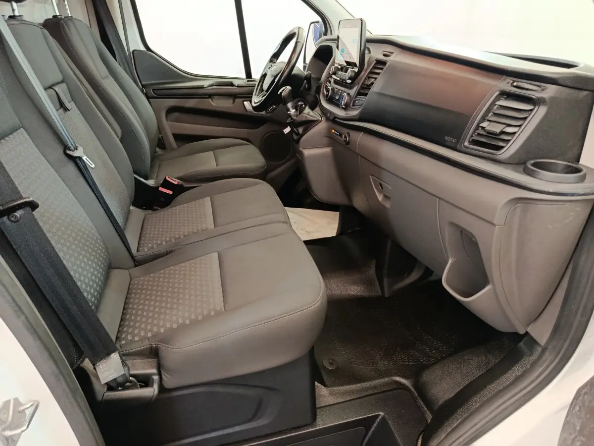 Vue intérieure côté passager du Ford Transit Custom 2020, montrant la banquette trois places et le tableau de bord gris.