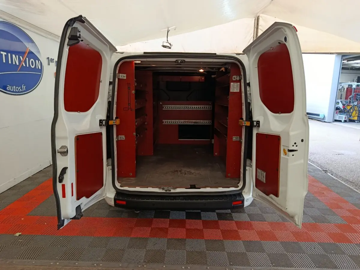 Vue arrière du Ford Transit Custom blanc 2020 avec portes ouvertes et aménagements de rangement rouges dans le coffre.