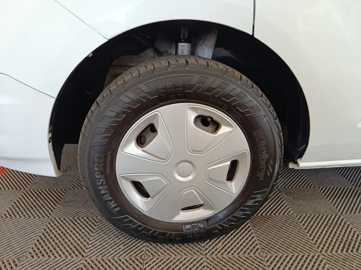 Gros plan sur la roue avant droite d’un Ford Transit Custom blanc avec enjoliveur gris et pneu Kleber.