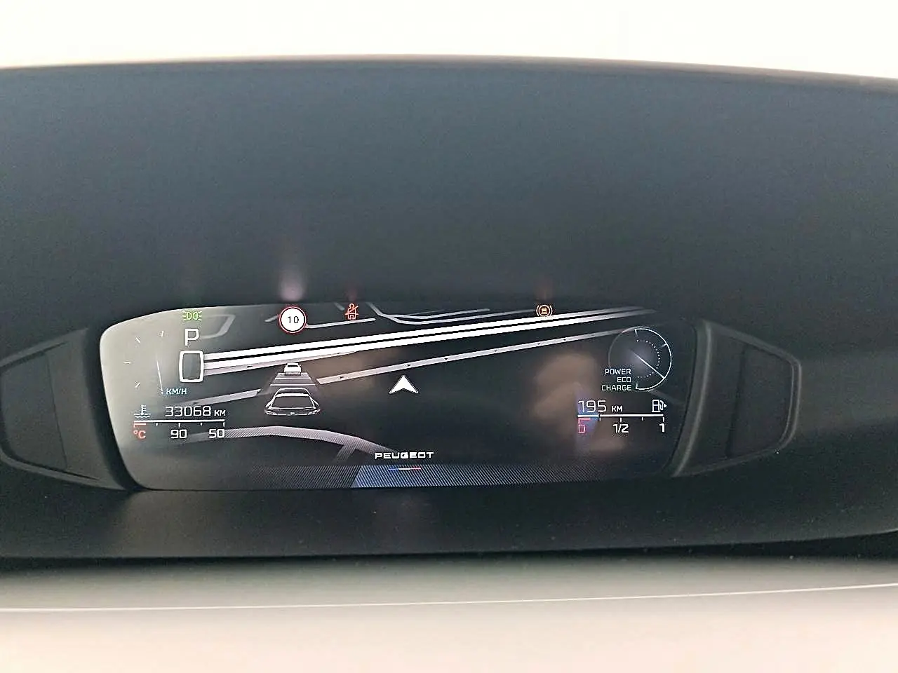Affichage numérique du tableau de bord de la Peugeot 408 Hybrid 145 allure, montrant la vitesse, autonomie et alertes.