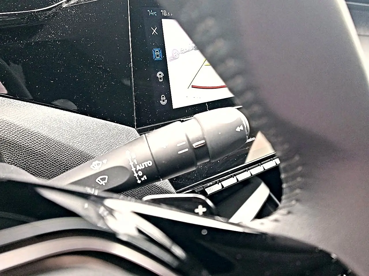 Gros plan sur la commande d’essuie-glace et l’écran tactile du tableau de bord d’une Peugeot 408 gris sélénite.
