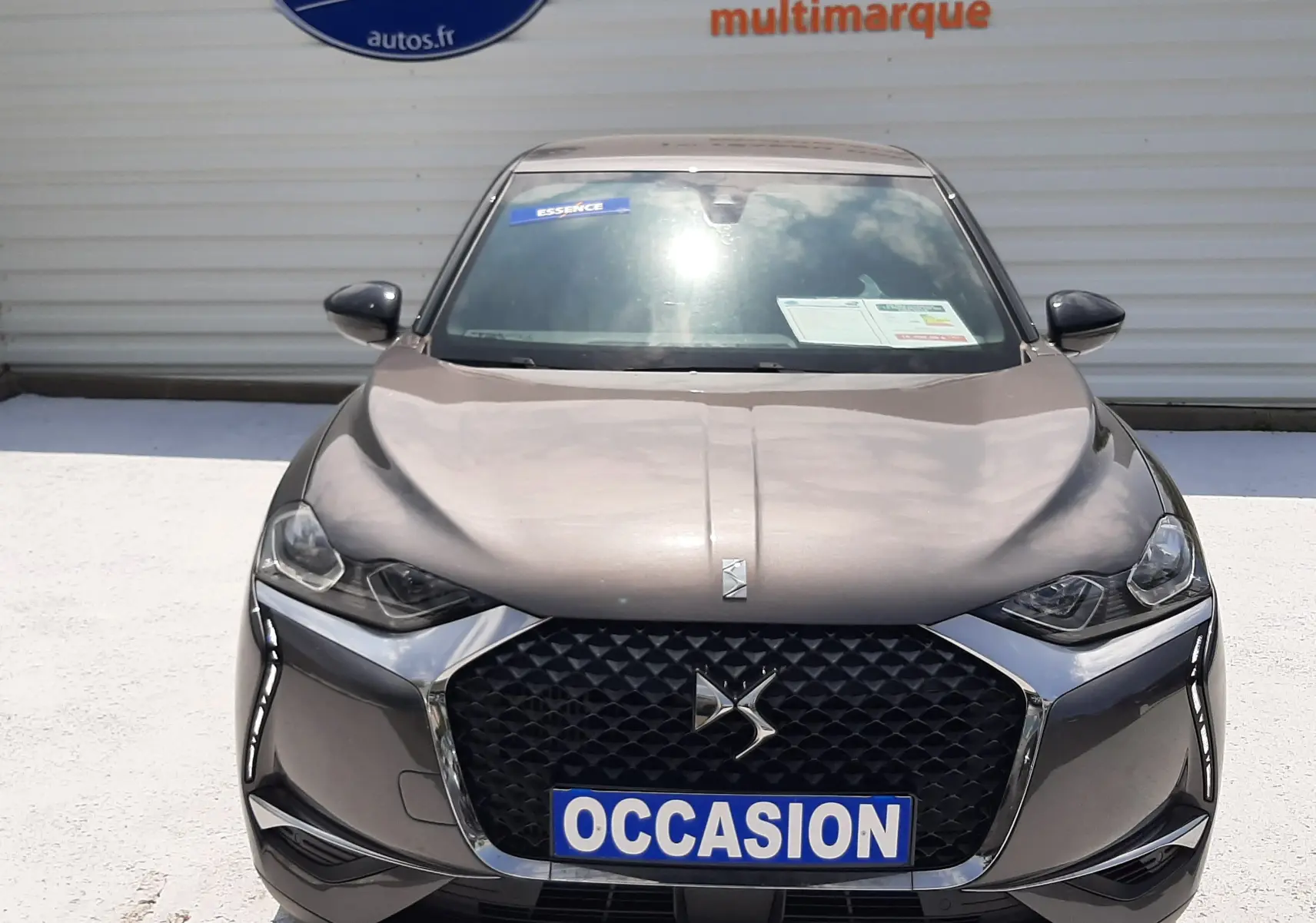 Vue frontale d'une DS3 Crossback gris platinium métal avec calandre noire et phares LED, affichant un panneau "OCCASION".