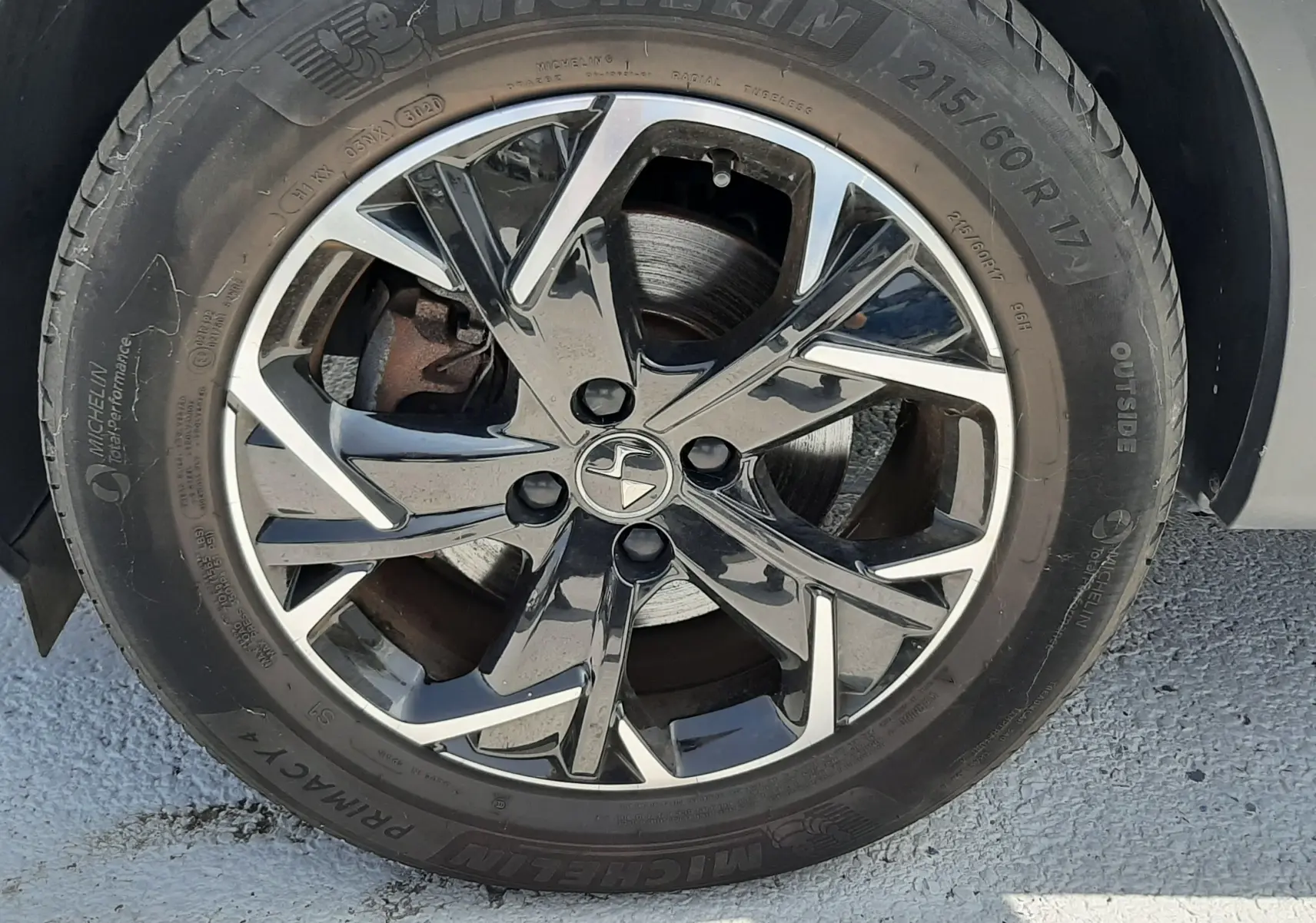 Gros plan sur la roue avant droite du DS3 Crossback gris platinium, avec jante alliage bicolore et pneu Michelin.