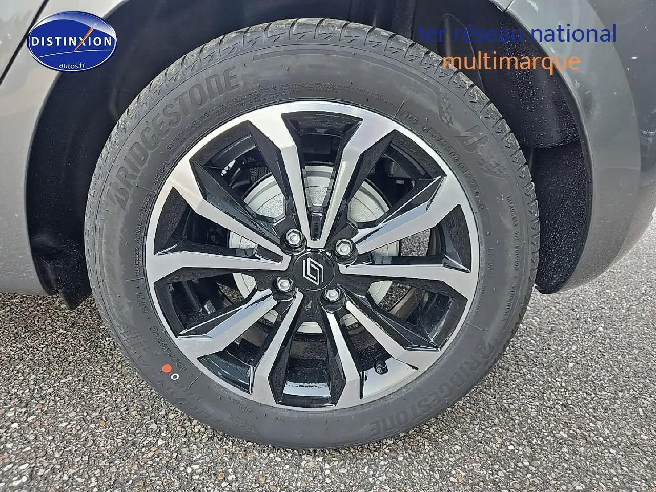 Gros plan sur la jante alu bicolore et le pneu Bridgestone d'une Renault Clio V gris schiste.