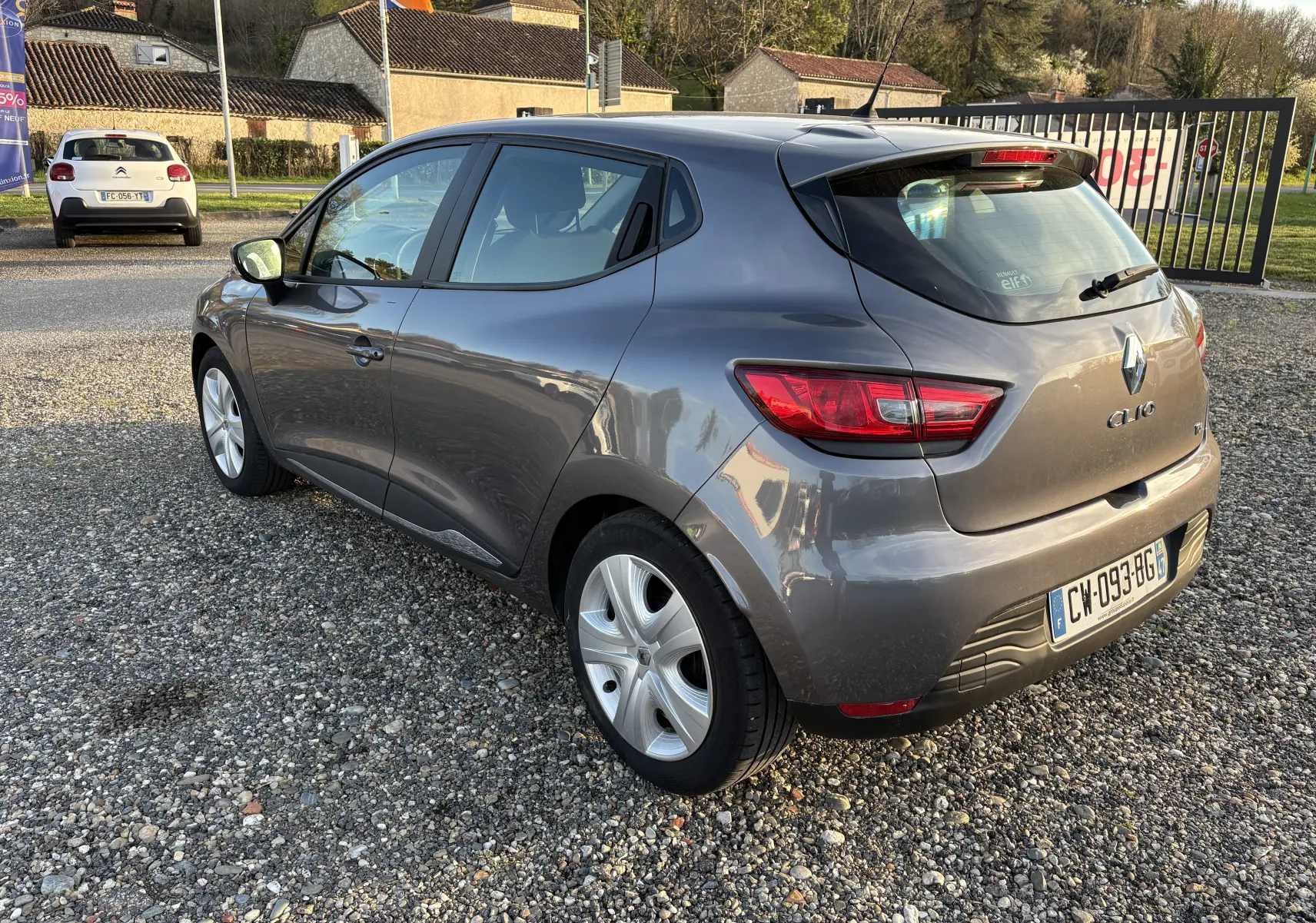 Vue 3/4 arrière droite d'une Renault Clio IV gris métallisé de 2013 avec feux arrière LED et jantes alliage.