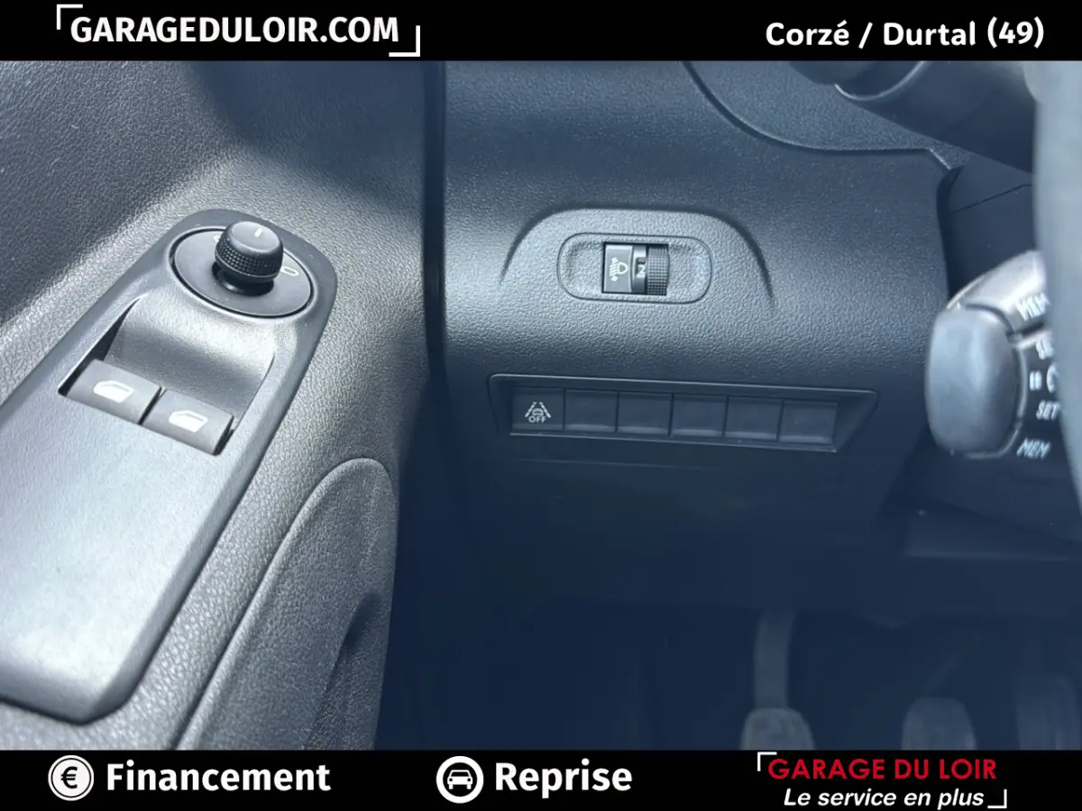 Détail intérieur côté gauche du Peugeot Rifter bleu 2024, avec commandes des vitres et réglage des phares.