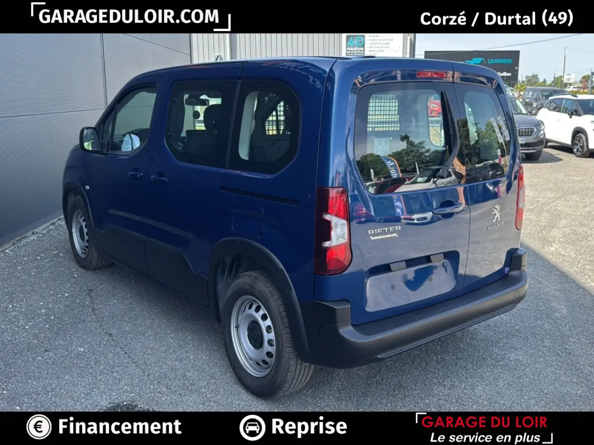 Vue 3/4 arrière droite d'un Peugeot Rifter bleu 2024 avec vitres arrière et porte latérale coulissante.