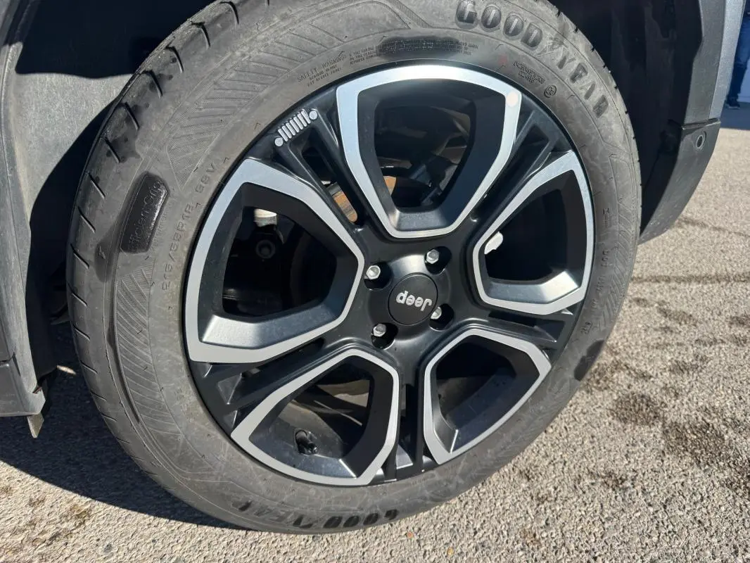 Gros plan sur la roue avant droite du Jeep Avenger gris, mettant en valeur le pneu Goodyear et l'aile du véhicule.
