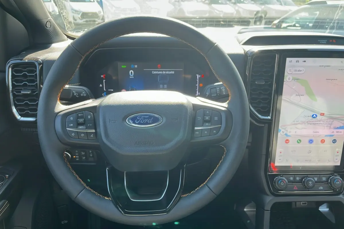 Vue intérieure centrée sur le volant cuir multifonctions et l'écran tactile vertical du Ford Ranger gris carbone 2026.