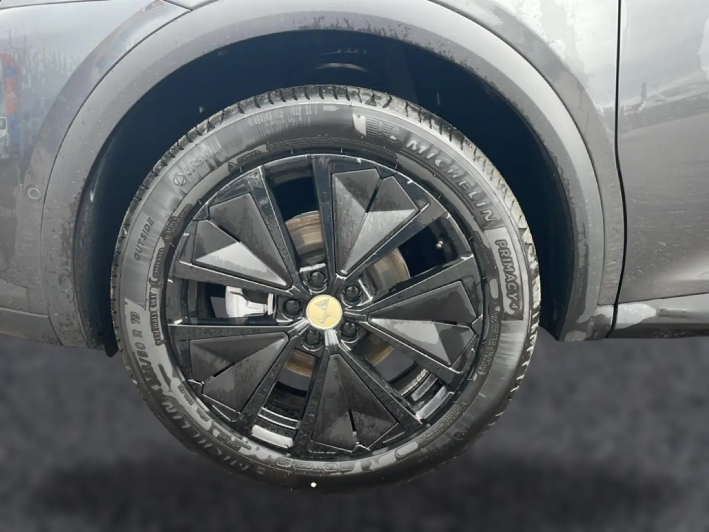 Gros plan sur la jante alu noire au design géométrique du côté gauche d’un DS7 gris titane 2026.