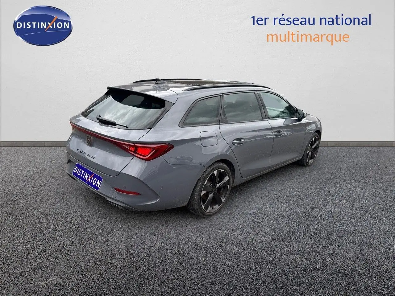 Vue 3/4 arrière droite d'une CUPRA LEON ST 2024 gris Graphene avec jantes noires et toit ouvrant panoramique.