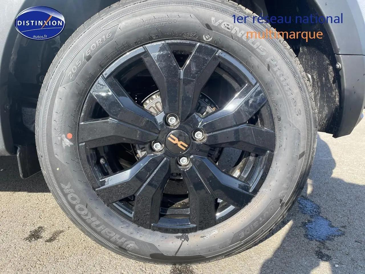 Gros plan sur la jante alu noire du côté avant droit d'une Dacia Sandero gris schiste 2025.