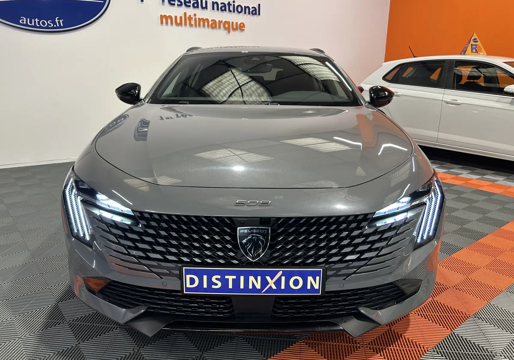 Peugeot 508 SW gris Selenium vue de face mettant en valeur la calandre noire et les feux LED distinctifs allumés.