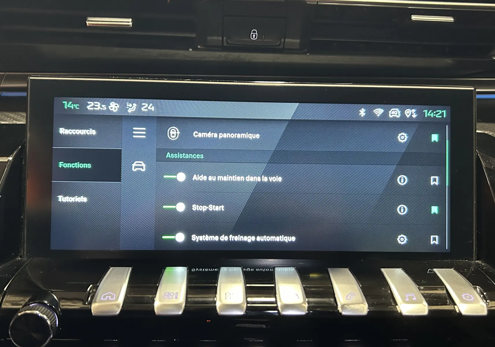 Écran tactile central de la Peugeot 508 SW 2024 montrant les assistances à la conduite, avec commandes piano en dessous.