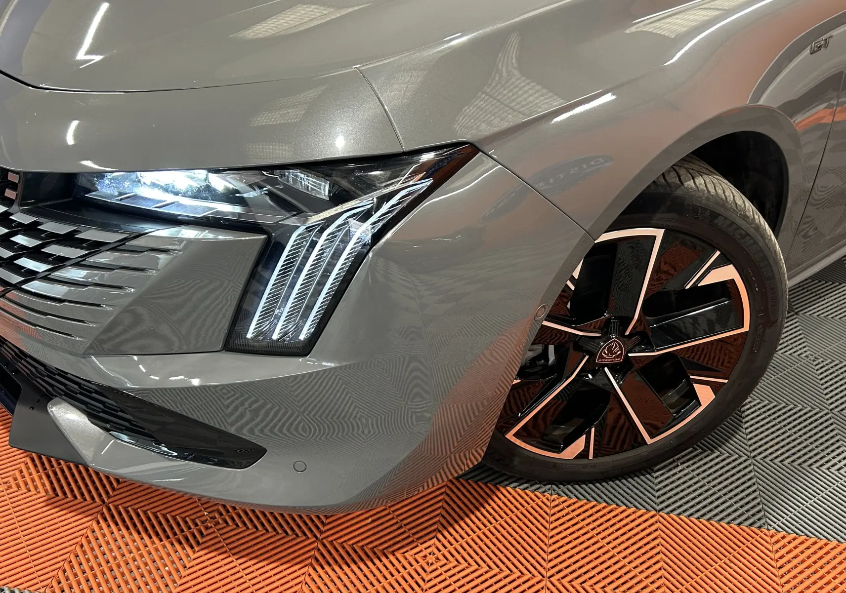 Gros plan sur l'avant droit gris Selenium du Peugeot 508 SW II Ph.2 avec feux LED et jante alliage noire et cuivre.