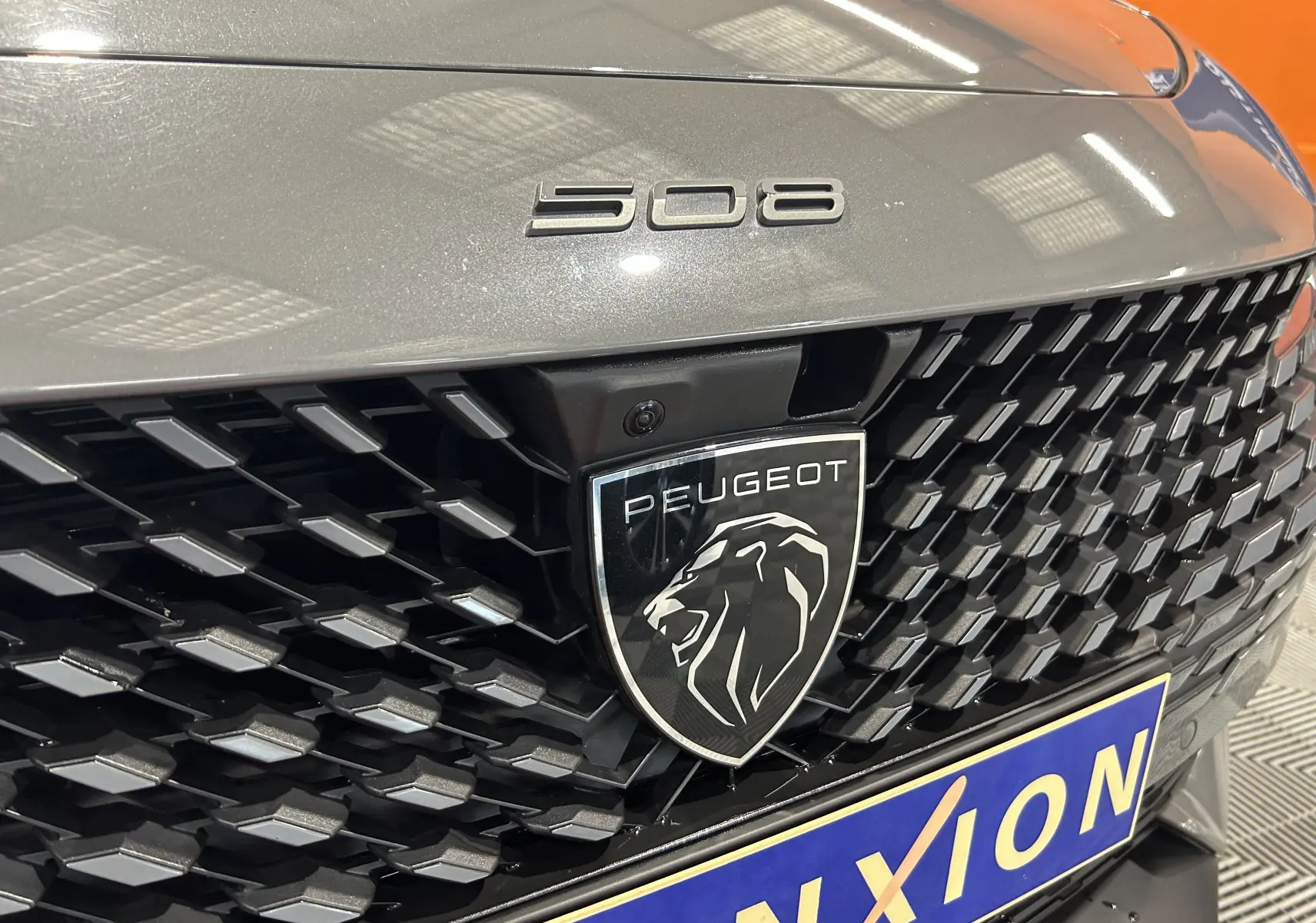 Gros plan sur la calandre avant gris Selenium du Peugeot 508 SW avec logo lion et badge 508 visible.