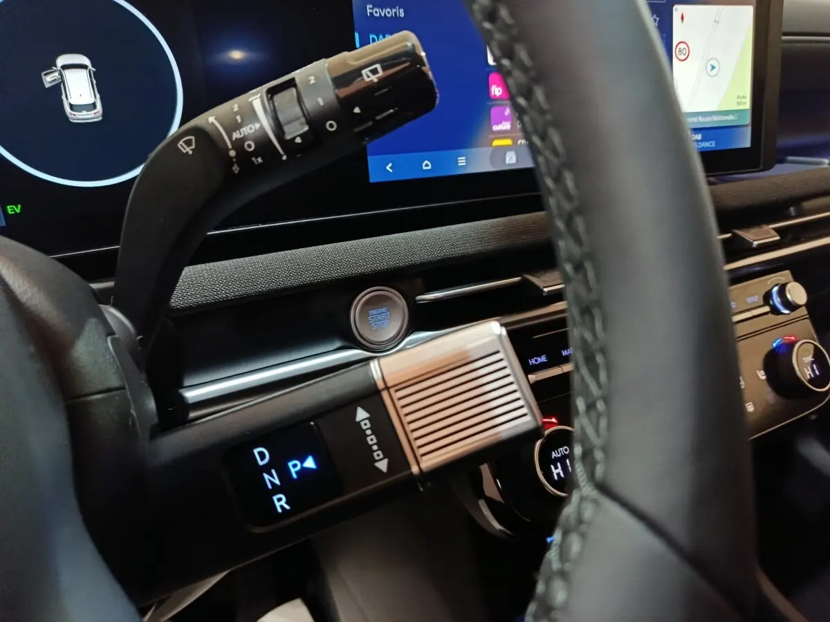 Gros plan intérieur sur la commande de boîte automatique et le tableau de bord numérique du Hyundai Tucson gris clair 2025.