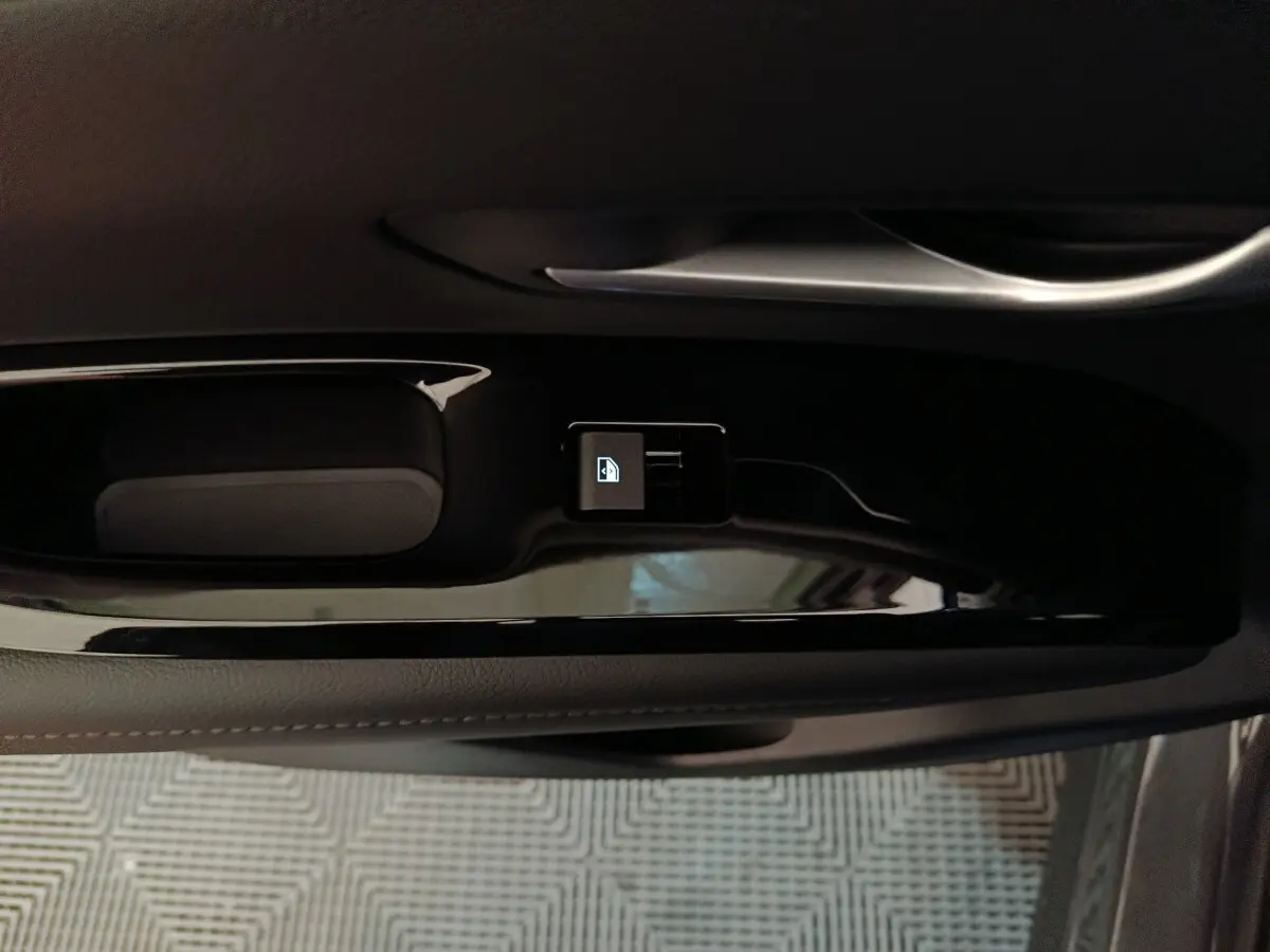 Gros plan sur la commande de verrouillage centralisée noire sur la portière intérieure côté conducteur du Hyundai Tucson gris clair 2025.