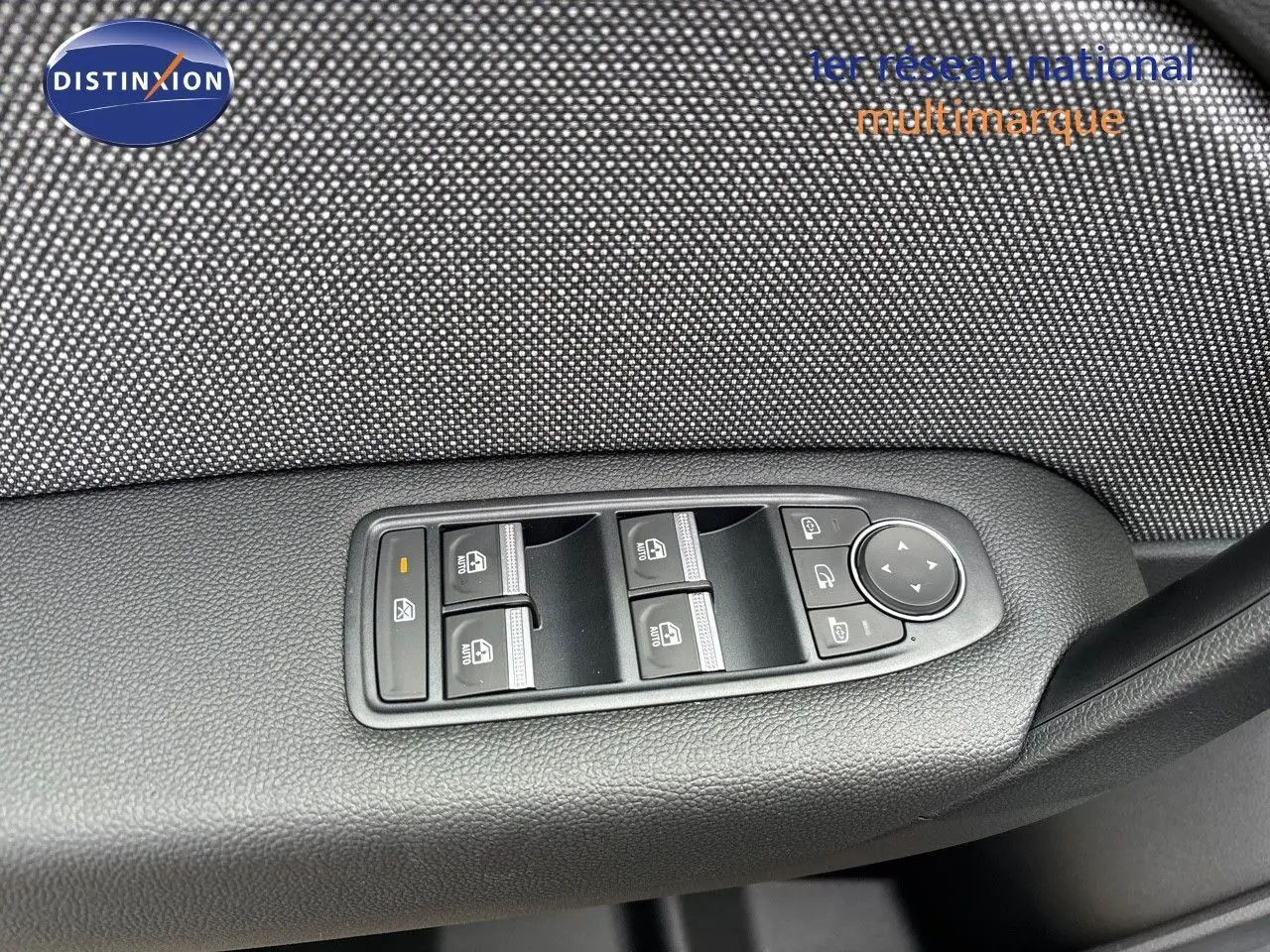 Gros plan sur les commandes des vitres électriques et rétroviseurs sur la porte côté conducteur du Renault Captur gris rafale 2025.