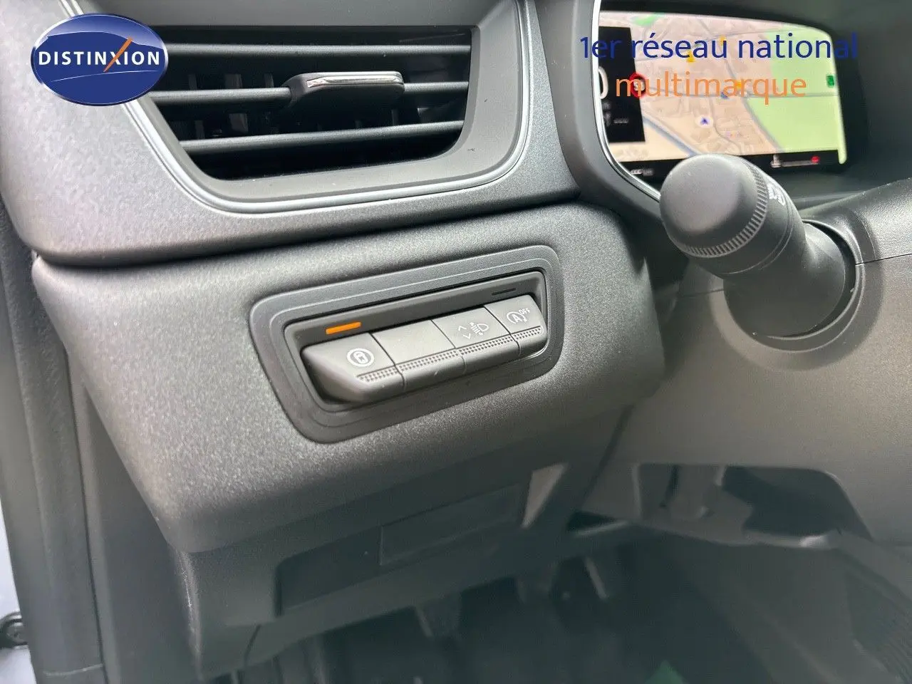 Gros plan sur les commandes à gauche du volant du Renault Captur gris Rafale métal avec écran tactile affichant la navigation.