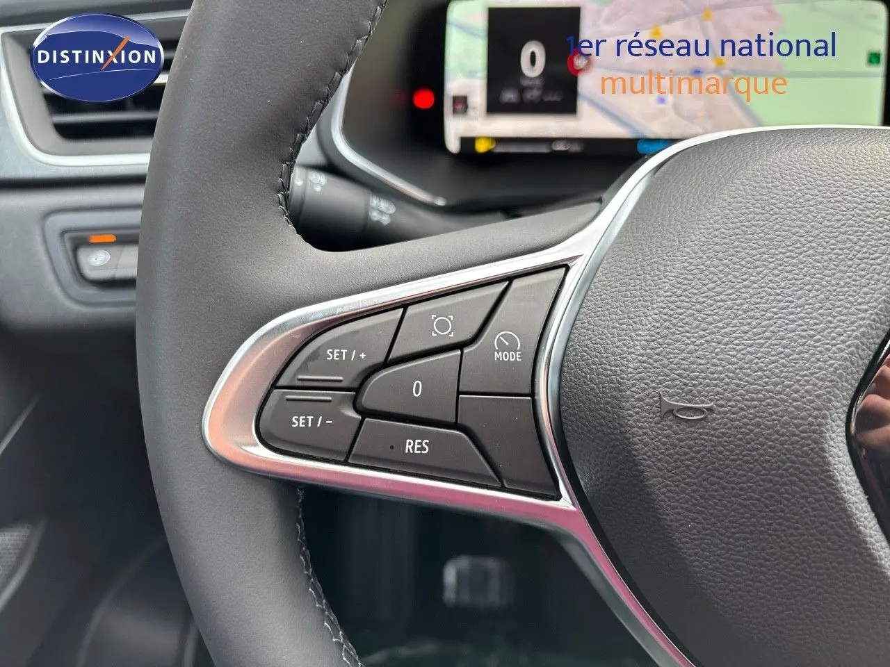 Gros plan sur le volant gris noir du Renault Captur 2025, mettant en valeur les commandes de régulateur de vitesse.