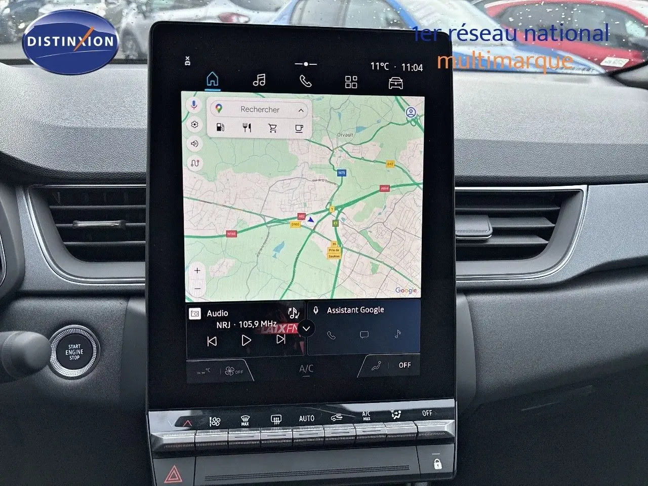 Vue intérieure centrée sur l'écran tactile vertical du tableau de bord du Renault Captur gris Rafale 2025 avec toit noir.