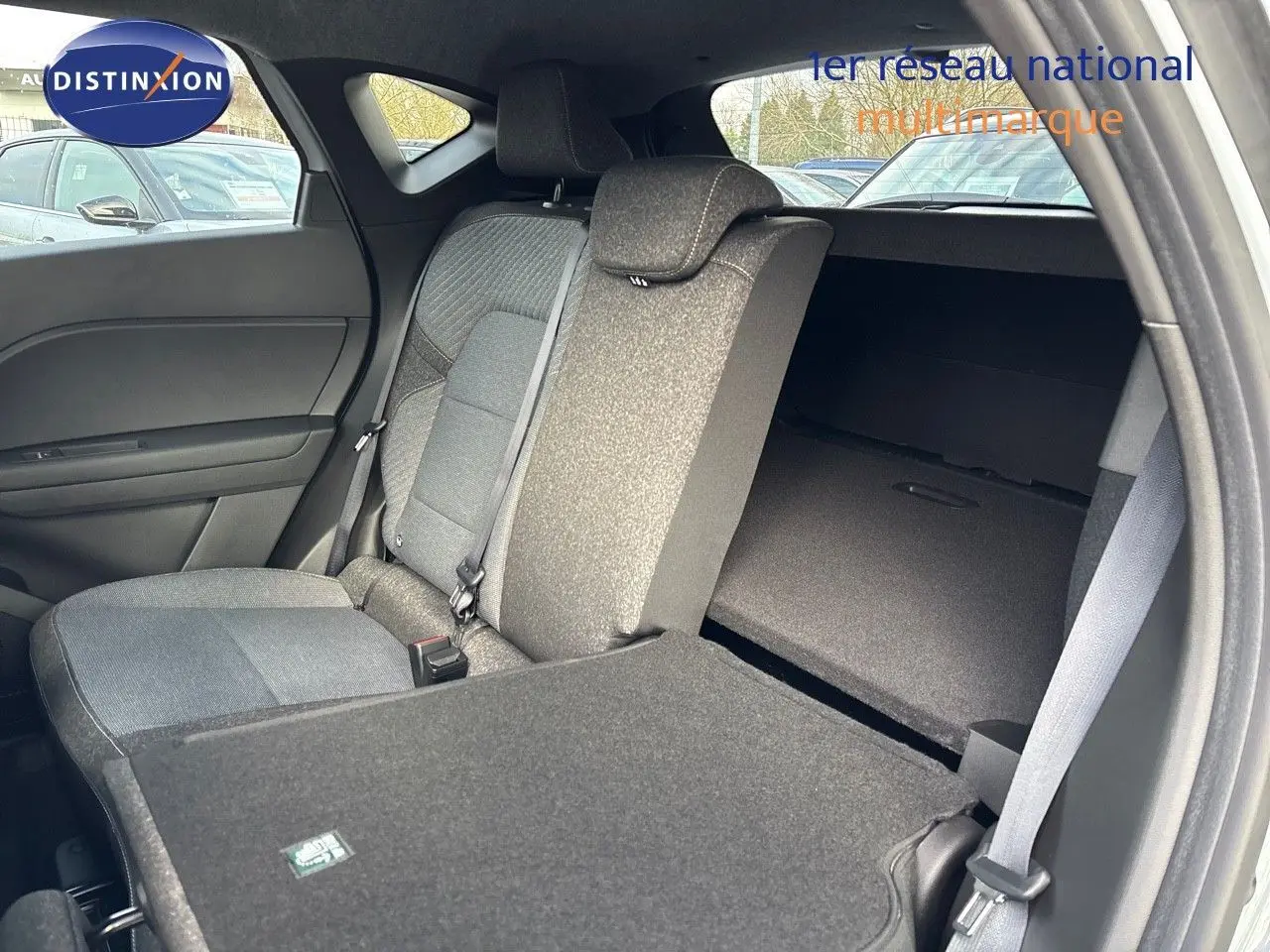 Vue intérieure côté gauche du Renault Captur II hybride 2025, siège arrière rabattable et tissu gris foncé.