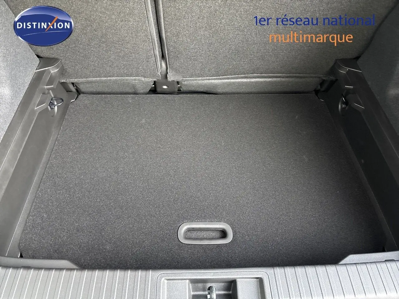 Coffre ouvert vu de dessus d’un Renault Captur II gris Rafale métal avec toit noir, montrant le plancher plat et les sièges arrière rabattus.