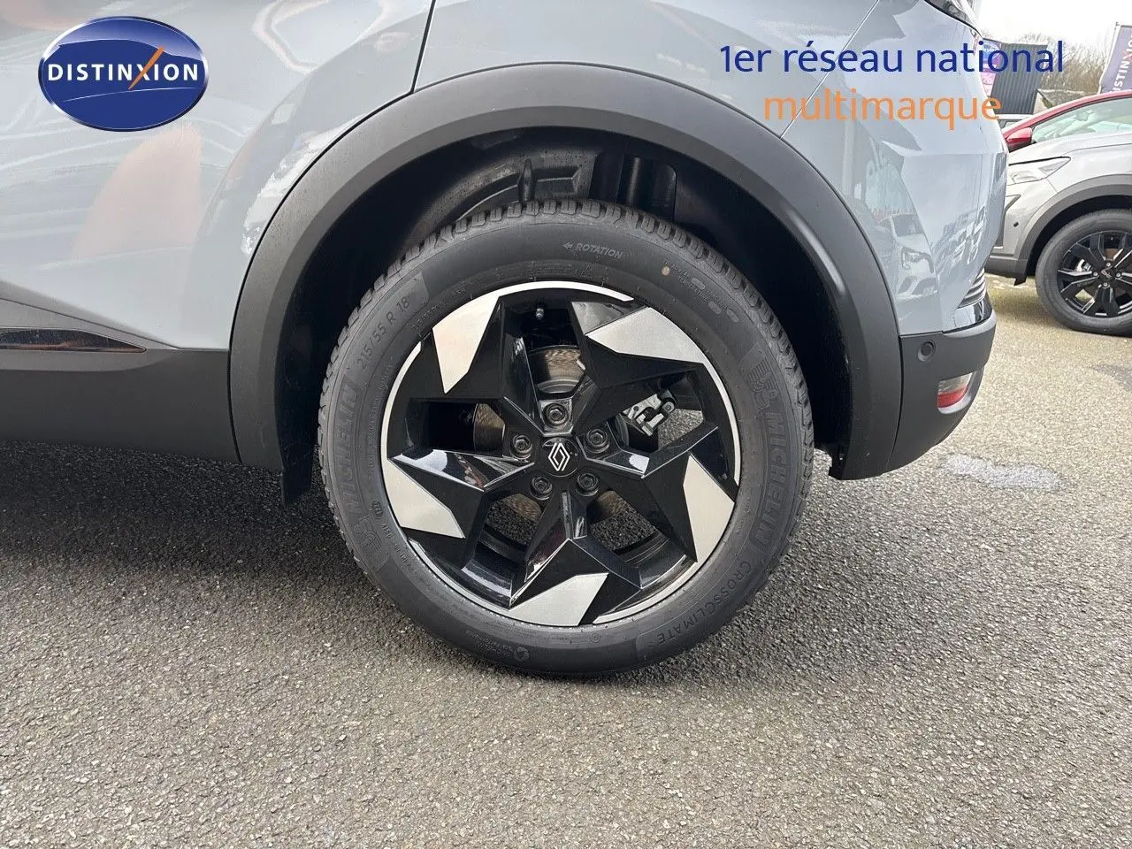 Gros plan sur la roue arrière droite du Renault Captur gris Rafale métal, soulignant la jante noire et argentée au design géométrique.
