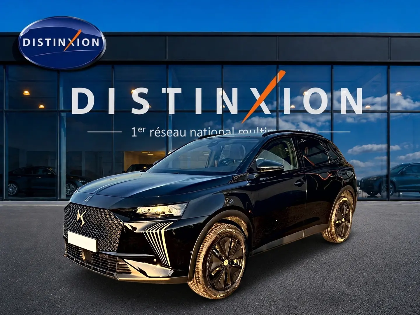 DS7 noir vue 3/4 avant droit, avec calandre distinctive DS et jantes alliage noires devant showroom Distinxion.