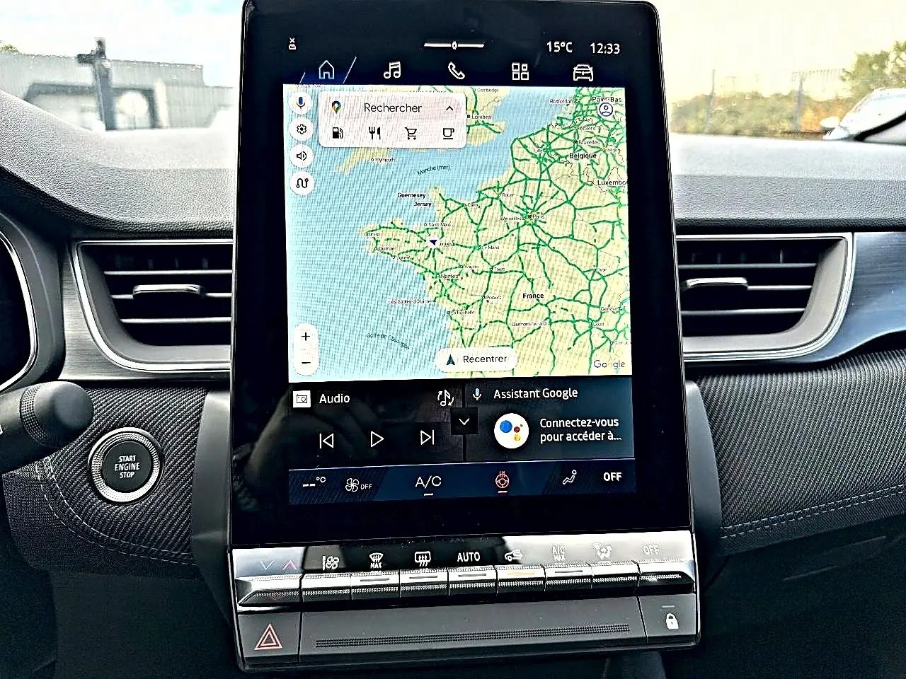 Vue intérieure centrée sur l'écran tactile du tableau de bord de la Renault Symbioz gris rafale avec commandes clim et bouton start/stop.