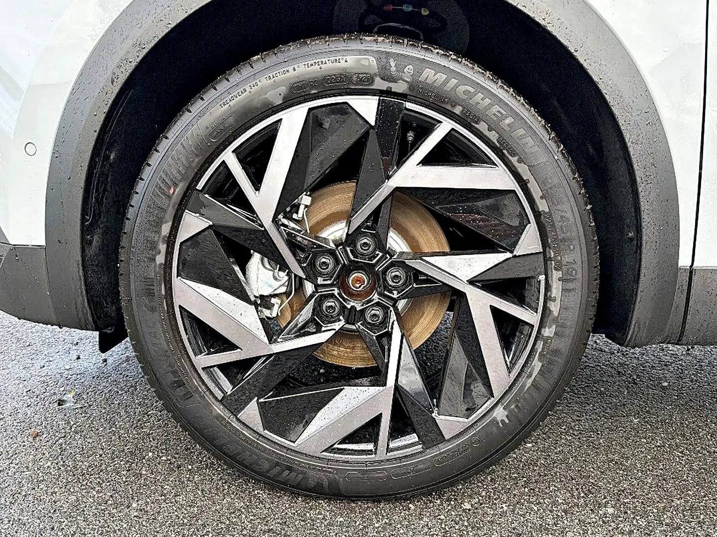 Gros plan sur la roue avant gauche avec jante alu noire et argent du Renault Symbioz gris rafale.