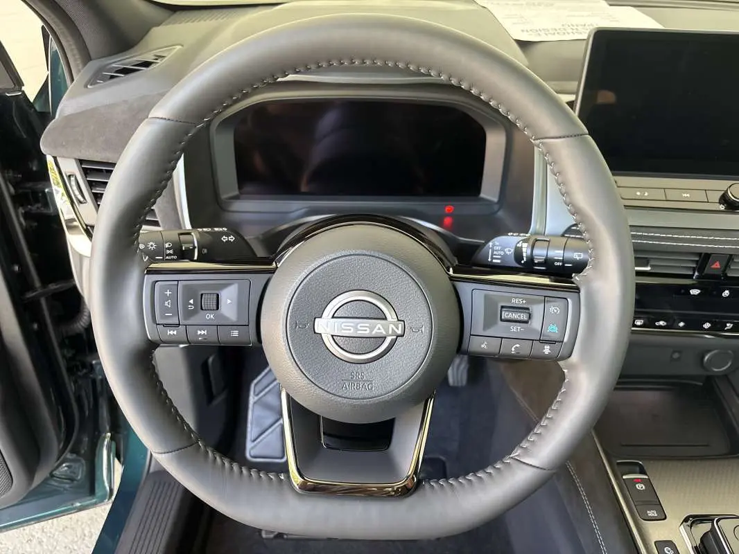 Vue rapprochée du volant cuir multifonctions du Nissan Qashqai E-POWER 2026, intérieur avec tableau de bord moderne.