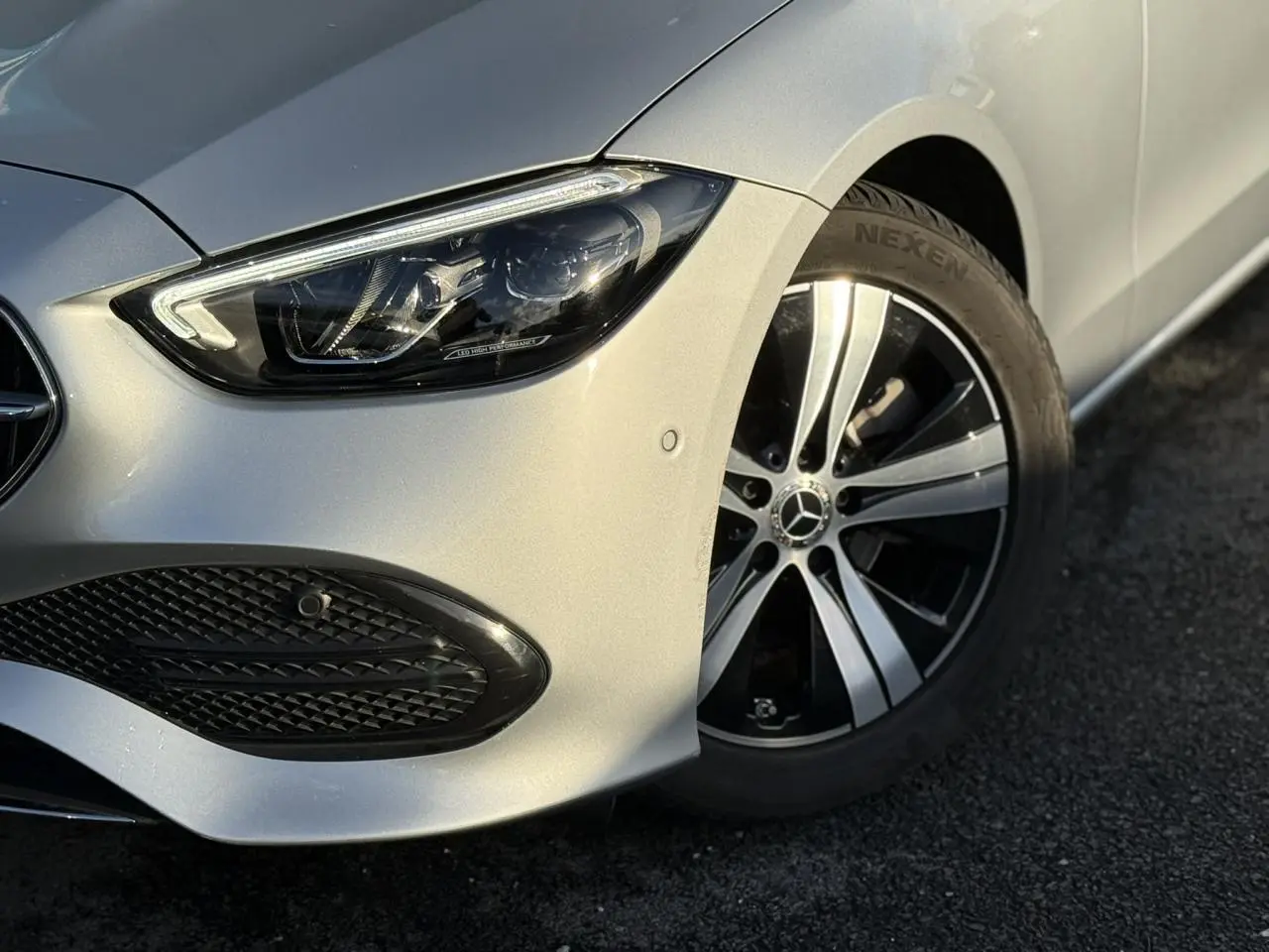 Vue 3/4 arrière droite d'un break Mercedes Classe C argent High-Tech avec feux LED et double sortie d'échappement chromée.