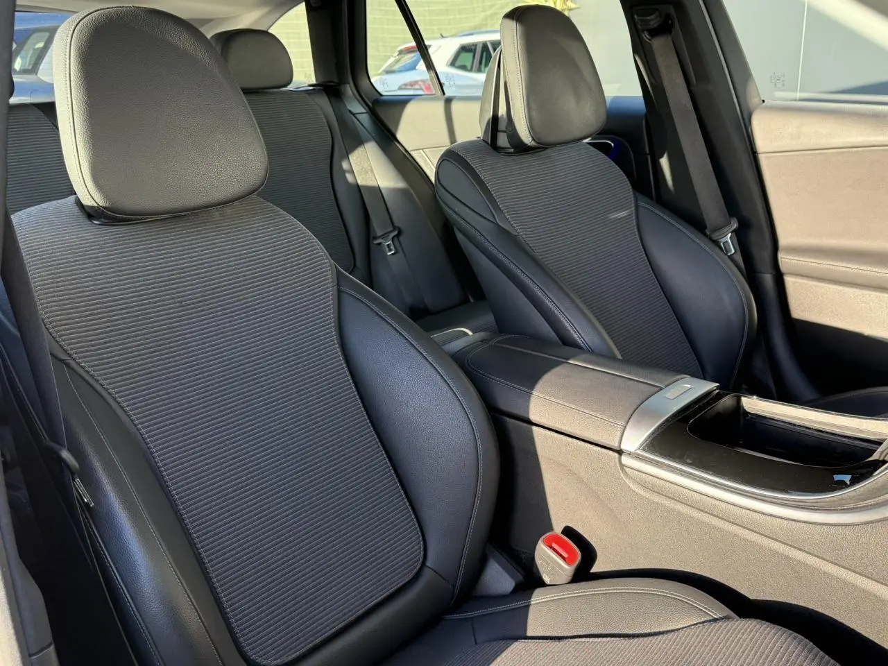 Gros plan sur le phare avant droit d'une Mercedes Classe C Break argent High-Tech avec jante alliage visible.