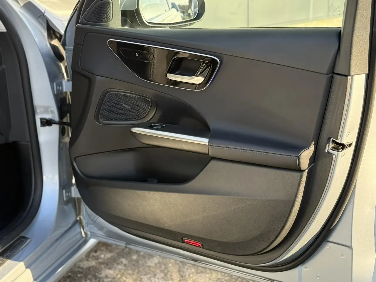 Intérieur noir du Mercedes Classe C Break 2023, vue côté conducteur avec écran tactile vertical et volant multifonction.