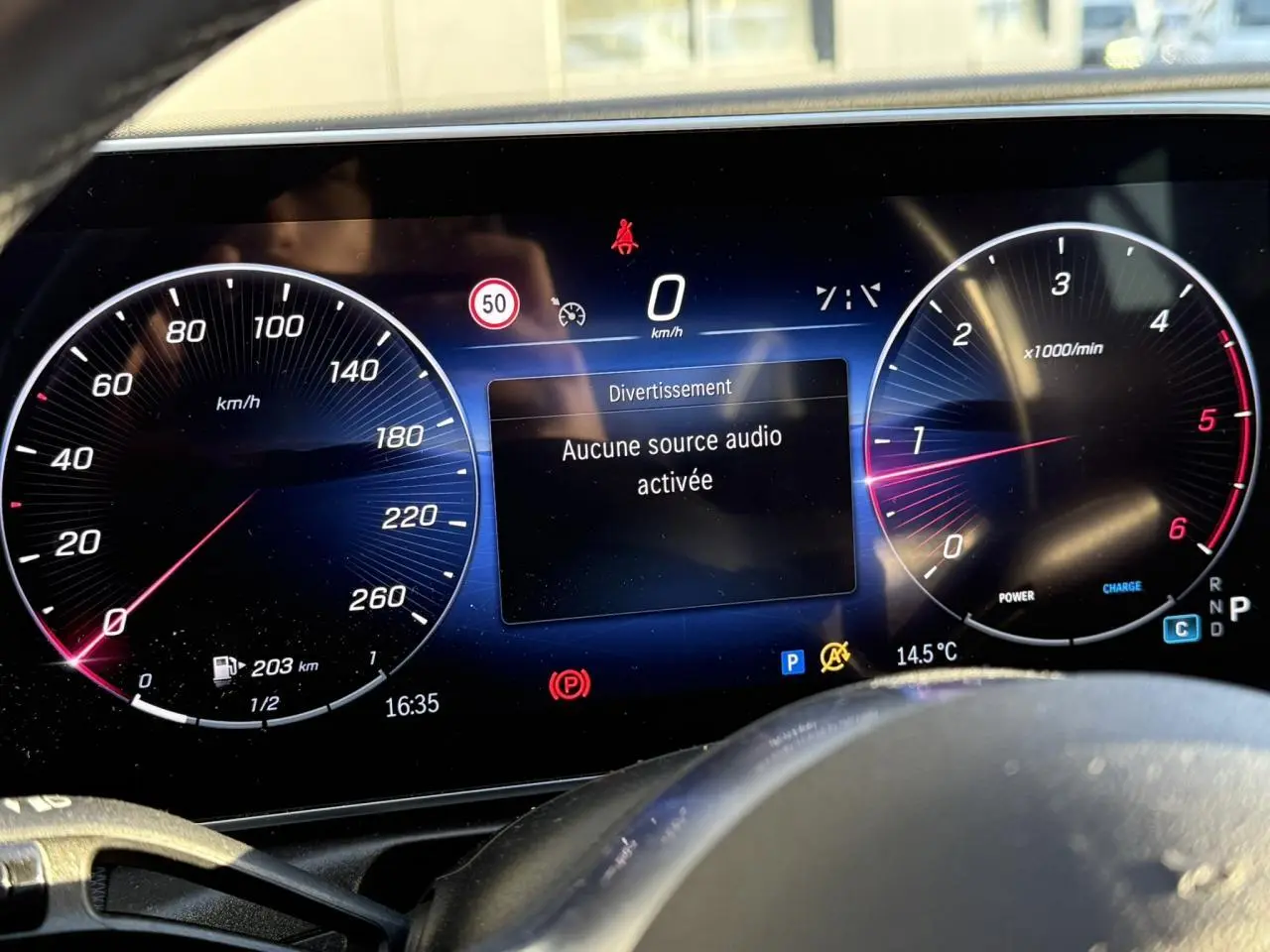 Détail de la porte côté gauche intérieure d'une Mercedes Classe C Break argent, avec poignée alu et bouton de siège chauffant.