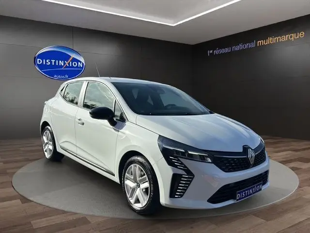 Renault Clio V blanche vue 3/4 avant gauche, avec feux LED distinctifs et jantes alliage 16 pouces.