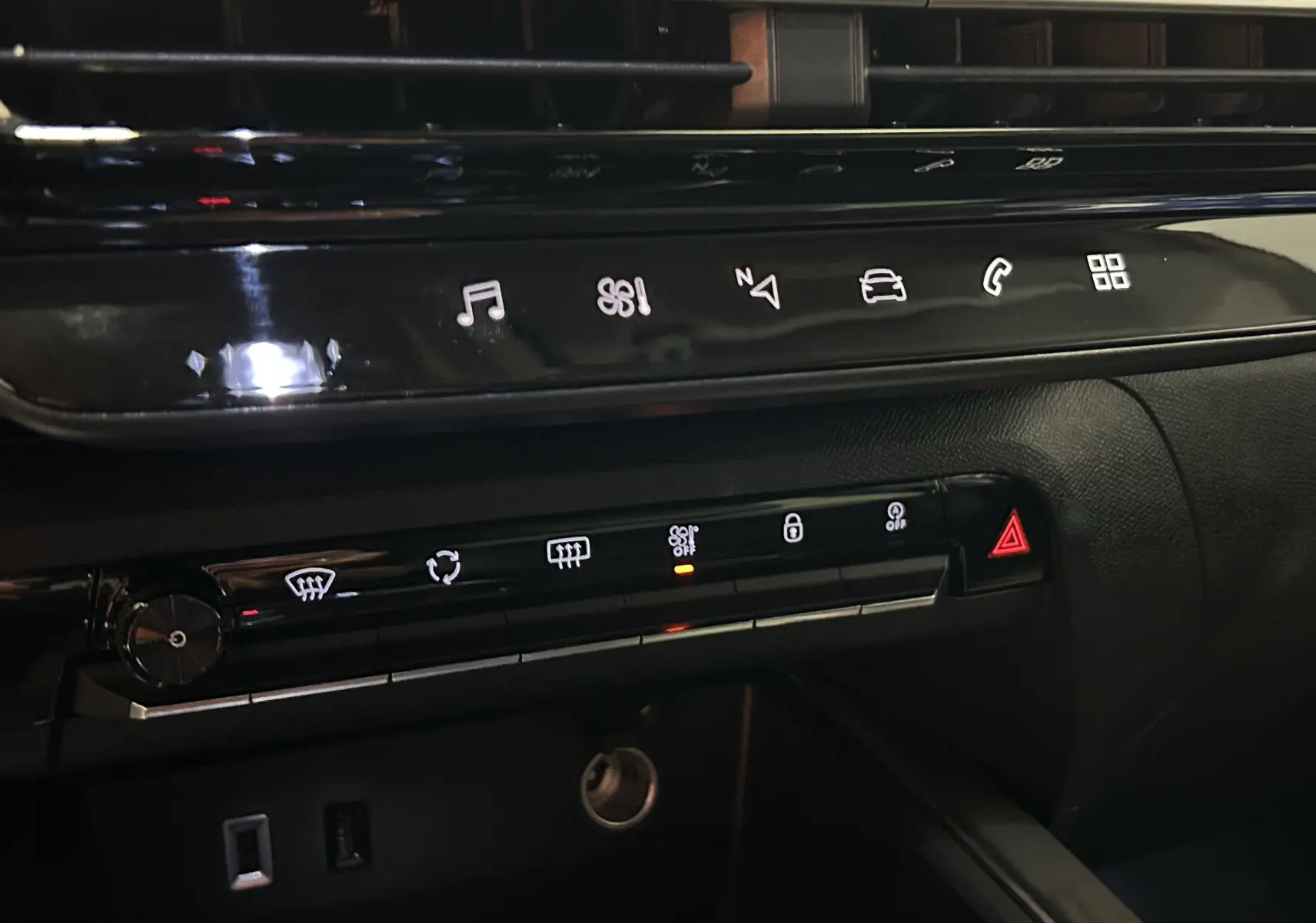 Détail de la console centrale noire brillante du Citroën C5 Aircross 2024 avec commandes tactiles et boutons lumineux