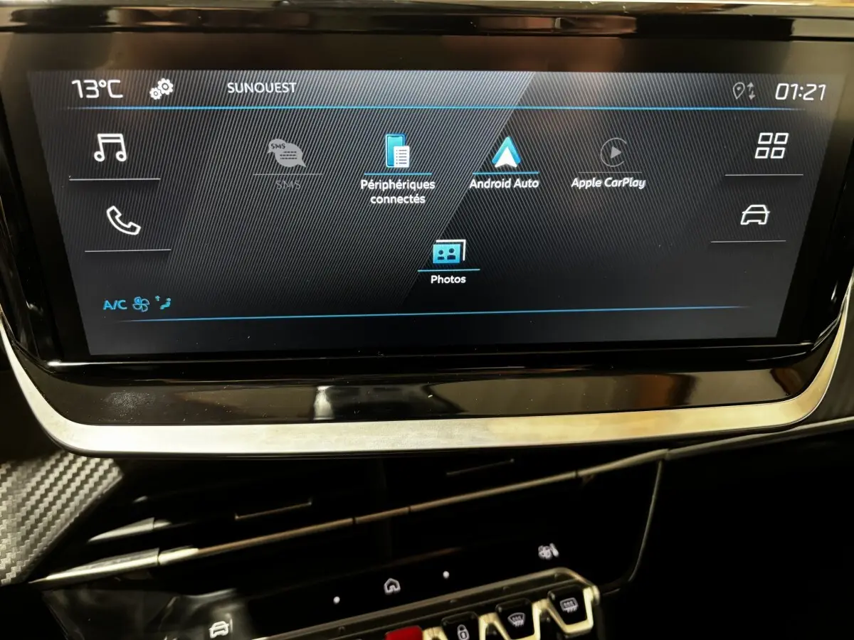 Écran tactile central affichant les options Apple CarPlay et Android Auto dans une Peugeot 208 jaune hybride.