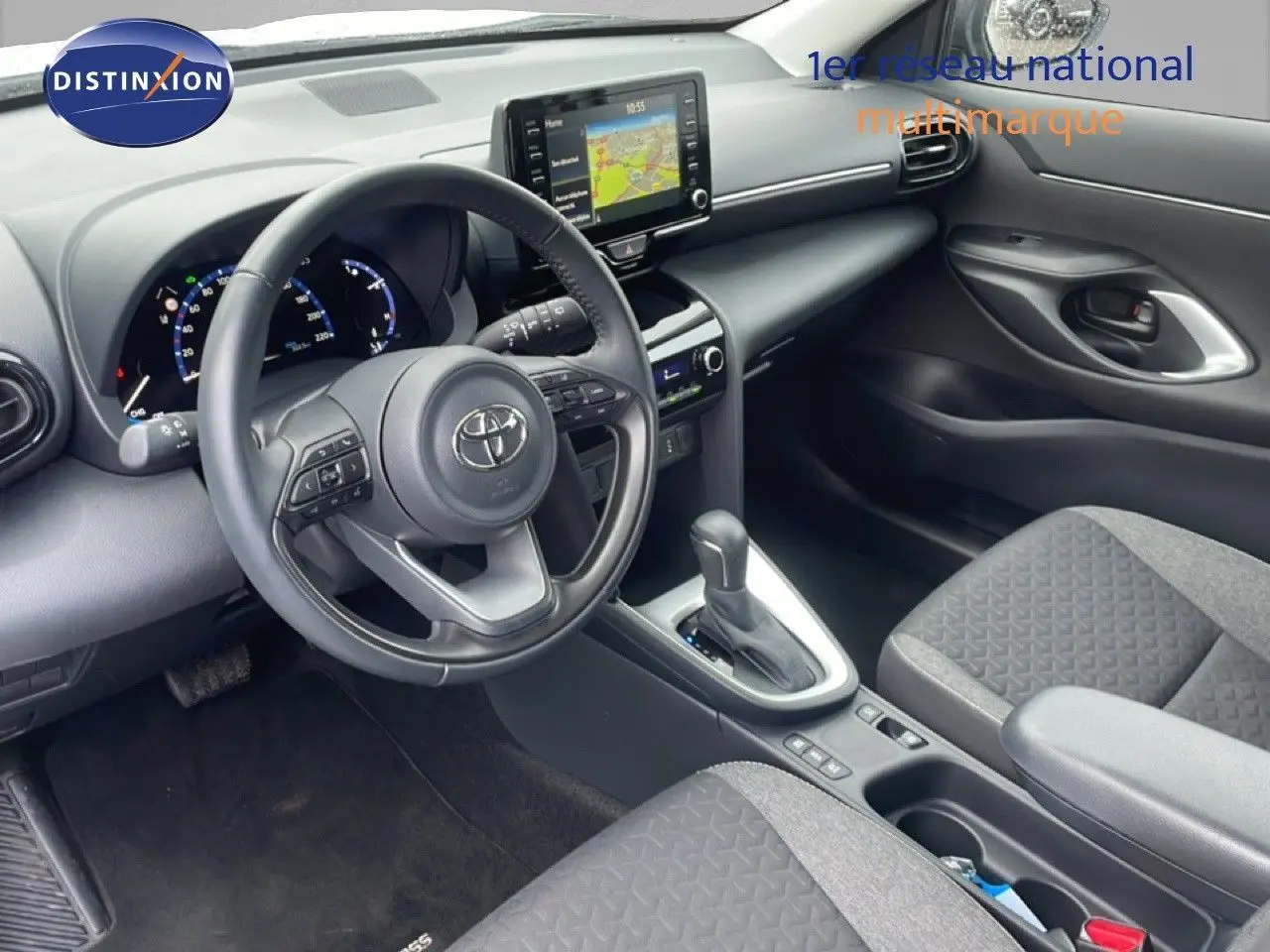 Vue intérieure côté conducteur de la Toyota Yaris Cross Hybrid 117ch Business 2024, tableau de bord et console centrale noirs.