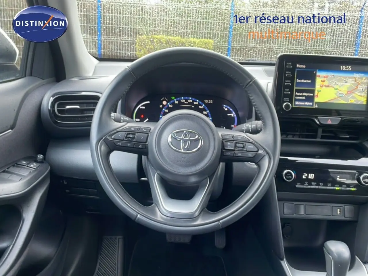 Vue intérieure centrée sur le volant noir de la Toyota Yaris Cross 2024, avec tableau de bord digital et écran GPS visible.