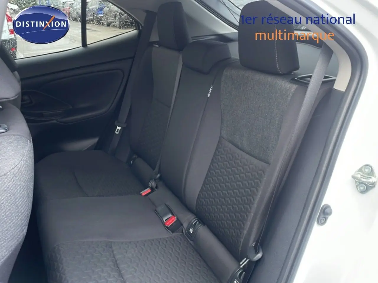 Vue intérieure côté droit sur les sièges arrière en tissu gris et noir d'une Toyota Yaris Cross Hybrid blanche 2024.