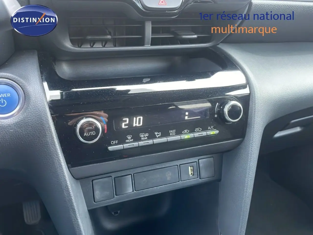 Vue rapprochée du tableau de bord noir de la Toyota Yaris Cross Hybrid 2024, avec commandes climatisation digitales.