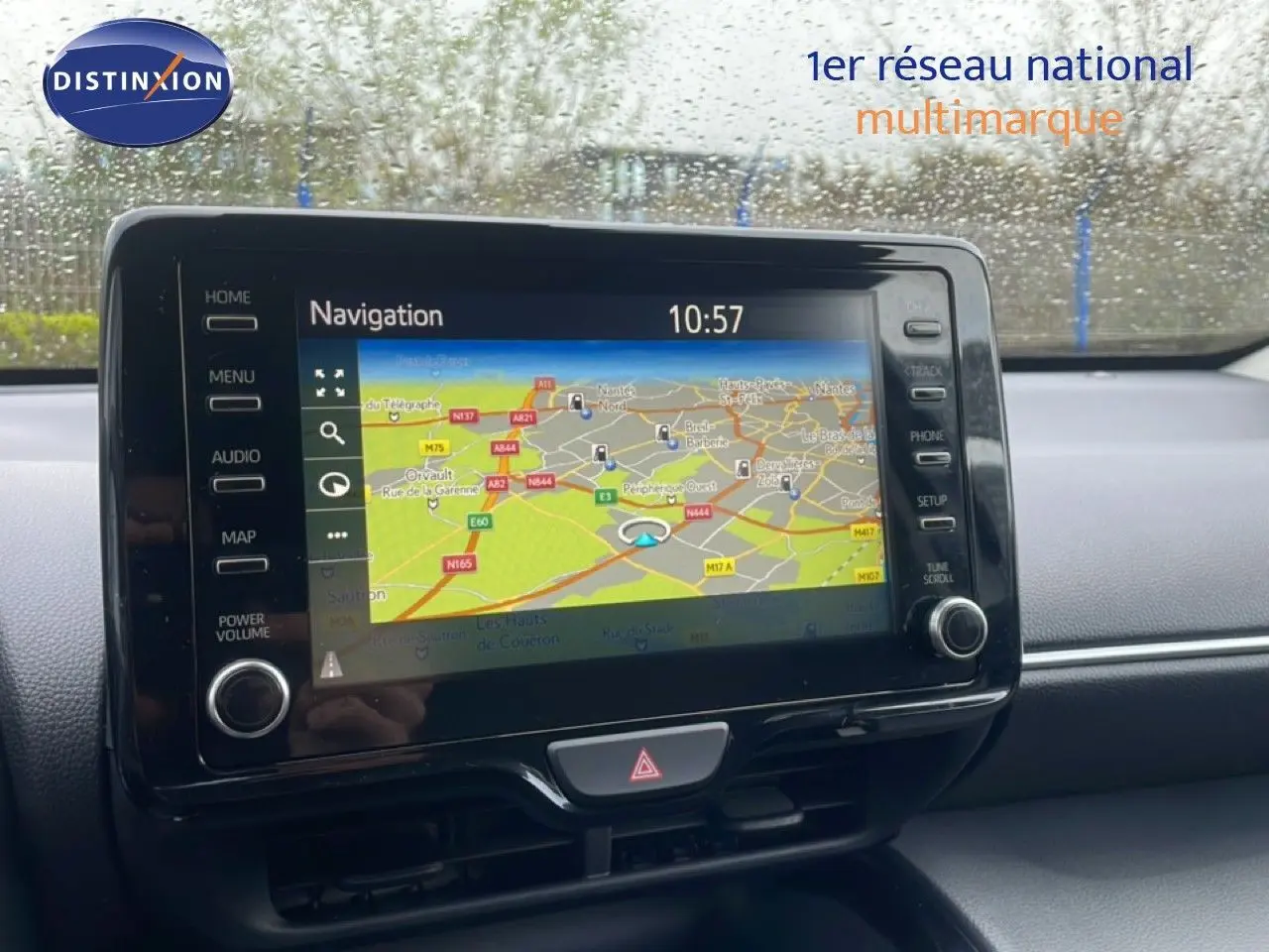 Écran tactile de navigation allumé dans l’habitacle d’une Toyota Yaris Cross blanche, vue de face.