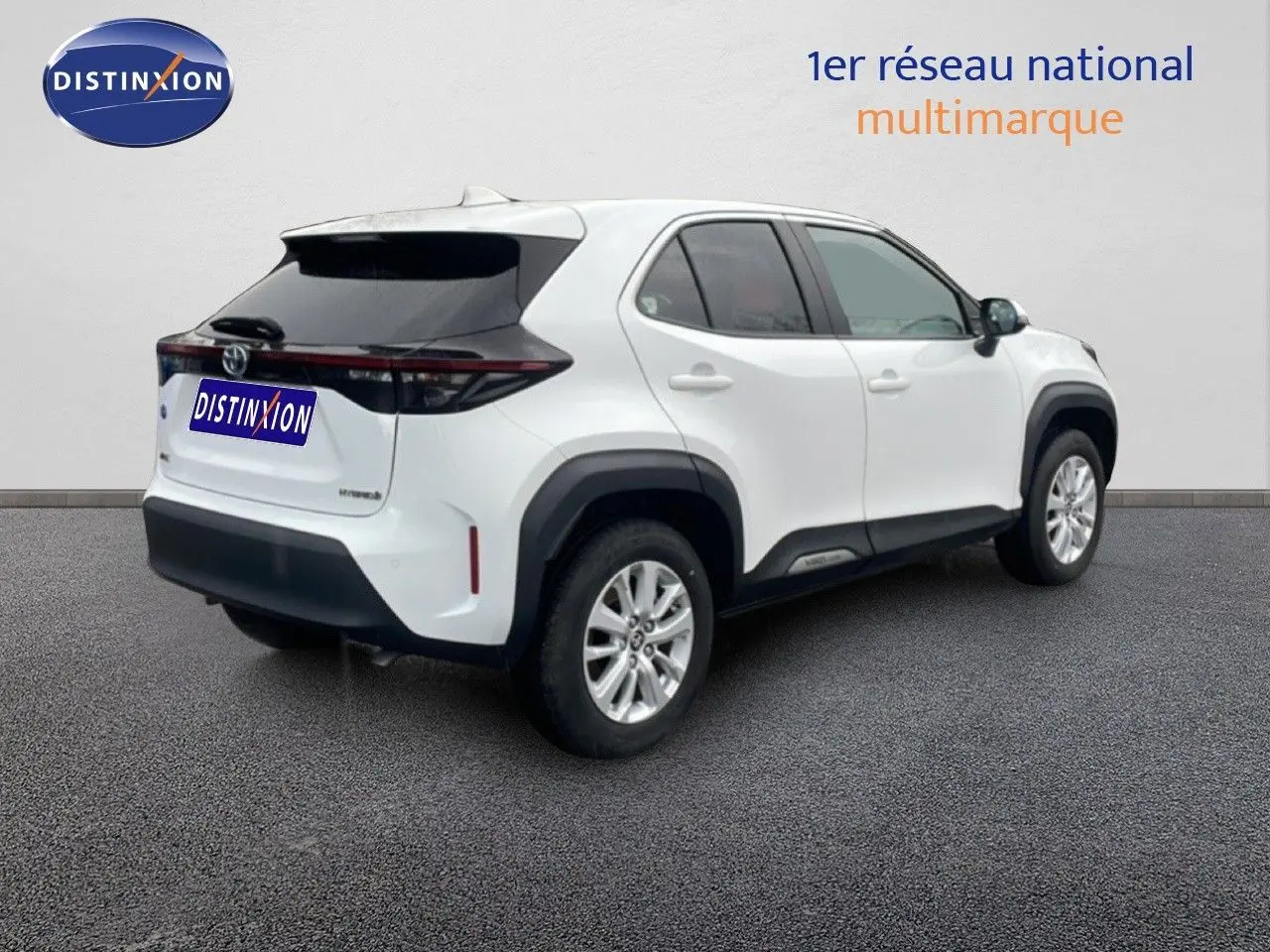 Toyota Yaris Cross Hybrid blanc vue 3/4 arrière droit, avec protections noires et jantes alliage argentées.