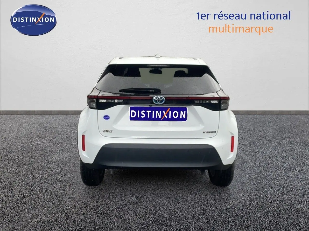 Vue arrière d'une Toyota Yaris Cross Hybrid blanche 2024 avec hayon noir et feux arrière horizontaux.