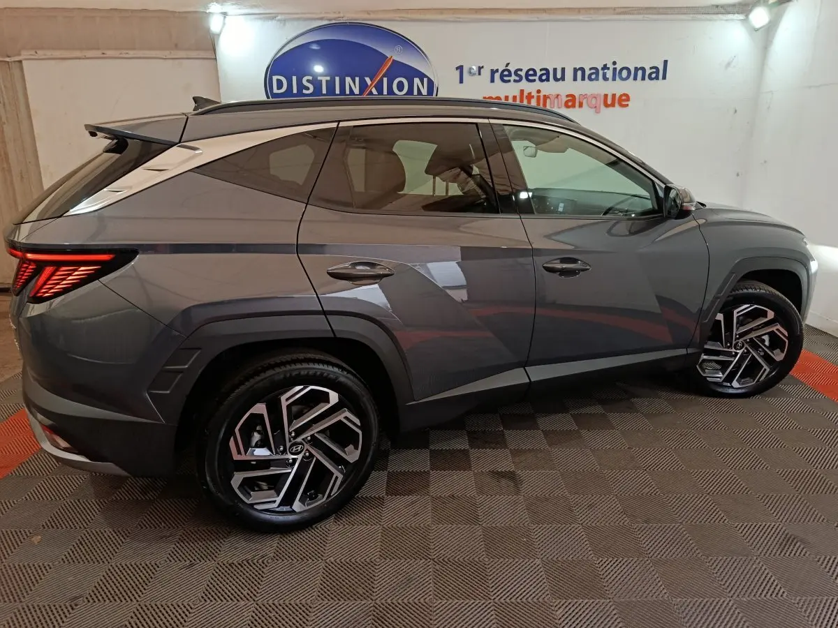 Vue latérale droite d'un Hyundai Tucson 1.6 Hybrid gris foncé avec jantes alliage et feux arrière LED distinctifs.